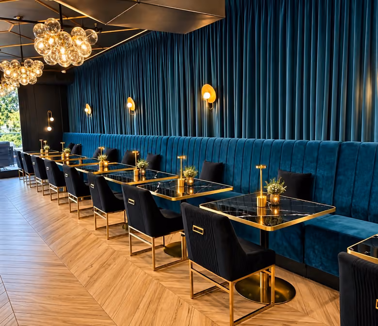 Teal velvet banquettes and set tables in the Il Vero dining room